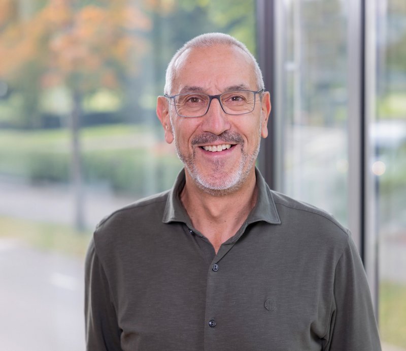 Axel Konhäuser IT-Beauftragter Porträt eines lächelnden älteren Mannes mit Brille, grauem Haar und kurzem Bart, der freundlich in die Kamera schaut.